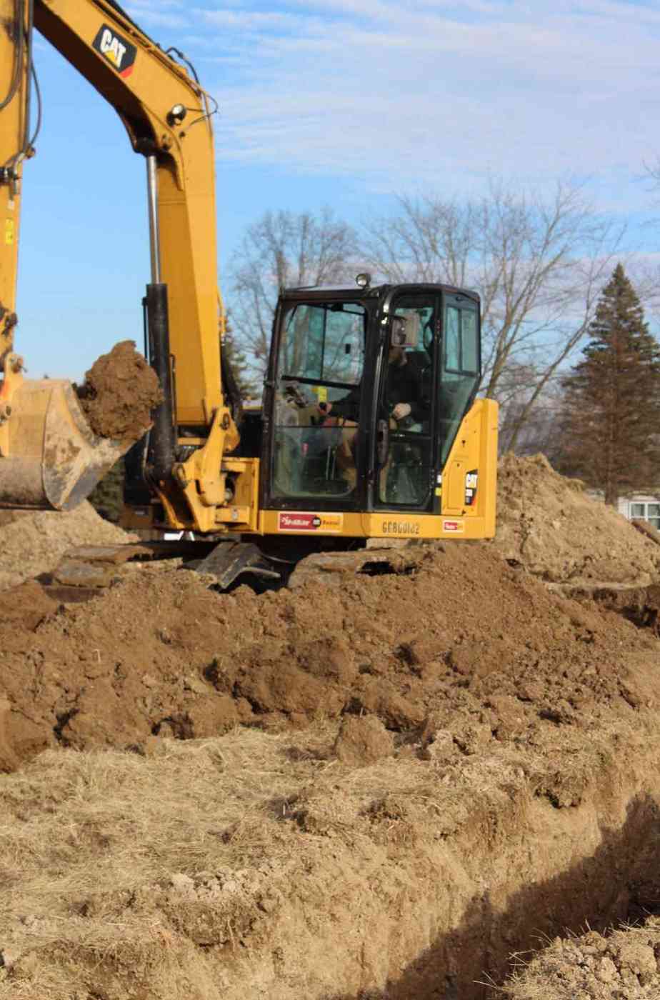 Excavator digging a foundation trench for a new home